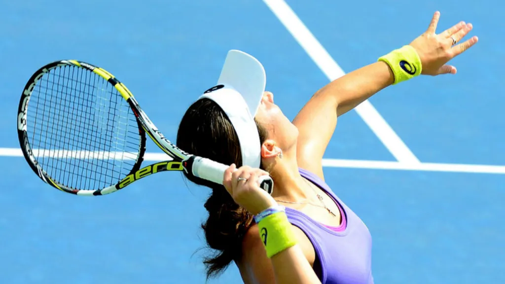 Two professional players competing on a blue hard court, one serving with a Babolat racket