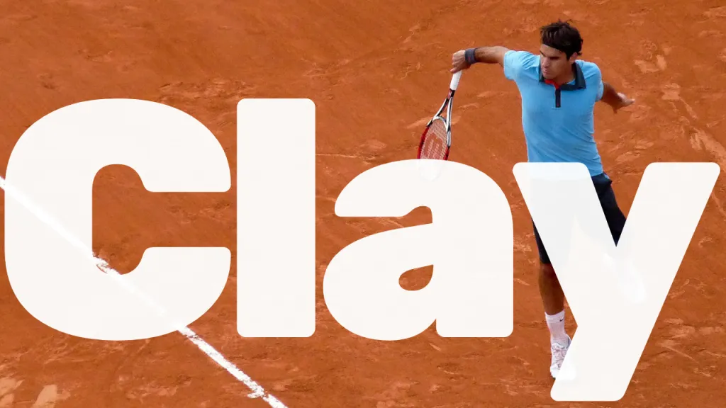 Red clay tennis court with visible surface texture and sliding marks