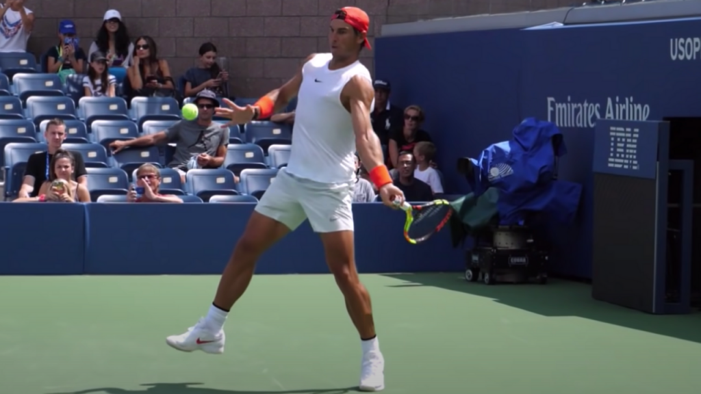 rafael nadal is generating effortless power from his back leg on his forehand side. the left foot is planted on the ground while is right foot is in the air for balance. he's about ready to make contact with the ball and probably generates more topspin than any other player on the tour.