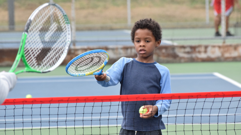 young quickstart tennis student holding a racket