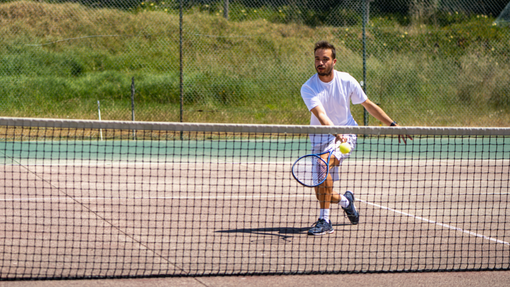 tennis player at net hitting a drop volley
